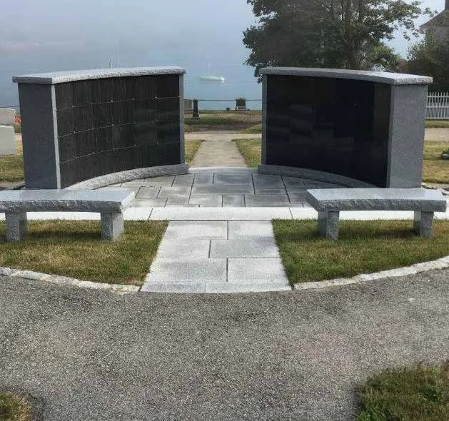 Two curved columbaria with granite benches overlooking the water at Hull Village Cemetery